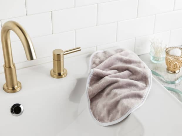 Photo of makeup remover towel resting on bathroom sink.