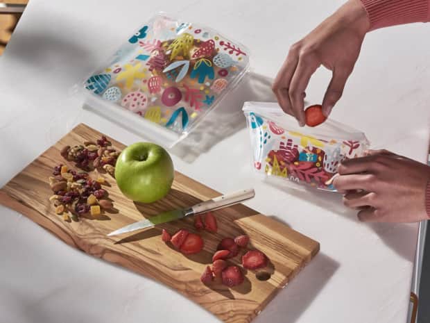 Person placing food into reusable storage bag