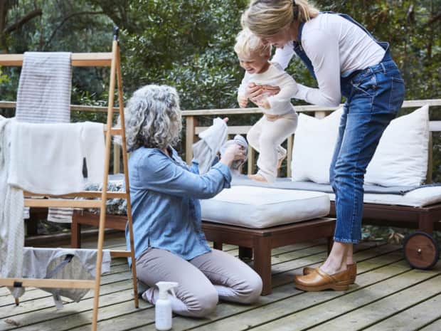Two women and baby with laundry outside