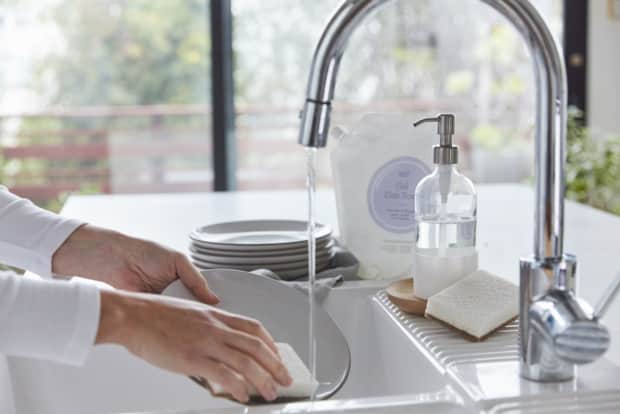 Photo of hands washing a dish in the sink