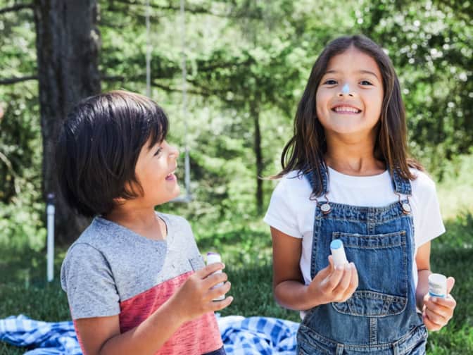kids applying sunscreen outside