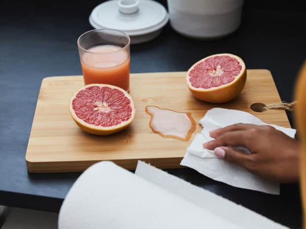 Photo of hand wiping grapefruit juice with paper towel
