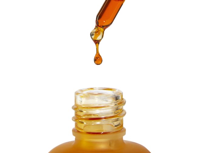 Image of oil dripping out of dropper into bottle below