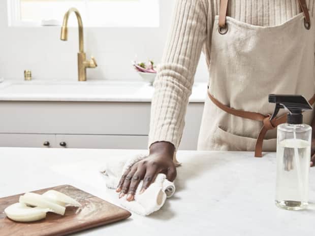 Woman wiping counter with cloth.