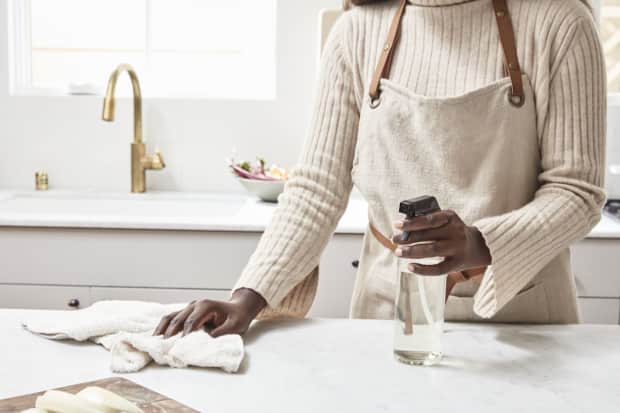 Woman spraying and wiping a surface
