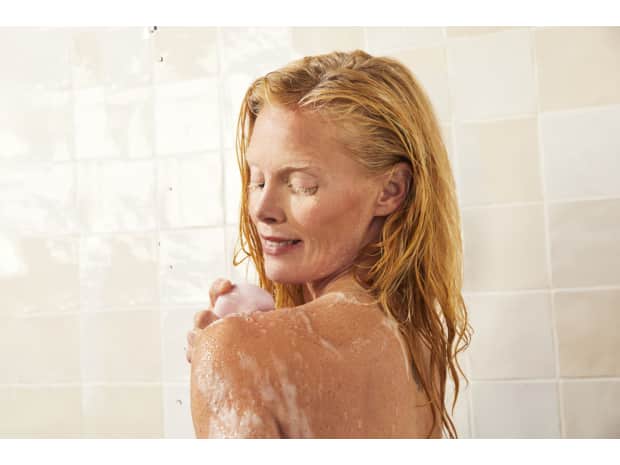 Woman using soap in shower