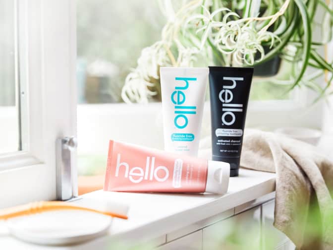 three hello toothpaste tubes on a bathroom counter