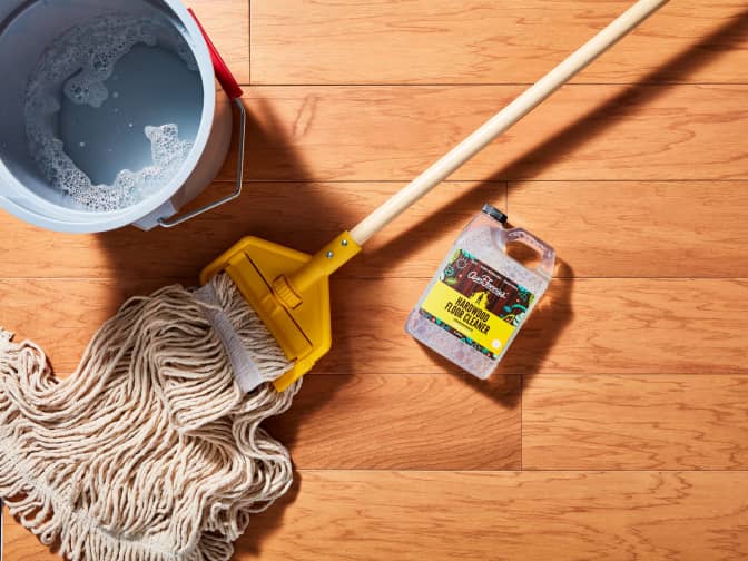 Image of Aunt Fannie's hardwood floor cleaner bottle on floor with mop