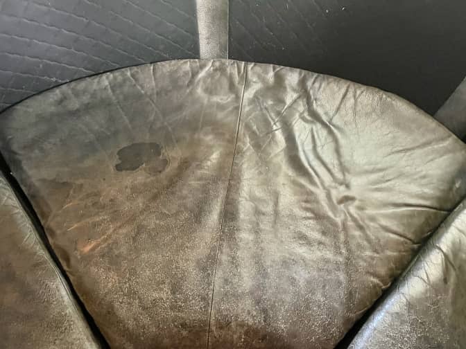 A leather couch with a stain.