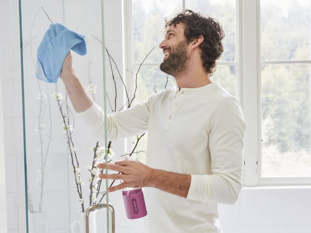 Image of a man cleaning a glass shower door