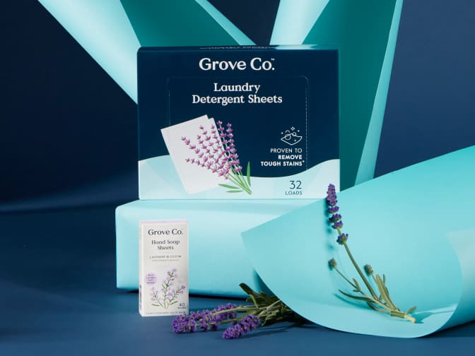 Image of Grove Co. Laundry Detergent Sheet box next to lavender flowers