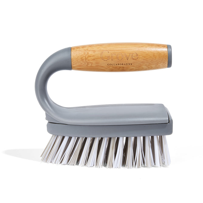 The Tub Handler + Deep Cleaner by Grove Co. is a sturdy scrub brush with a wooden handle and grey bristles for cleaning. It features a comfortable grip engraved with Grove and is made from recycled plastic, featuring replaceable brush heads for longevity and sustainability.