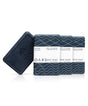 Oars + Alps Exfoliating Bar Soaps are in dark packaging with wave designs. An unwrapped charcoal soap at the front displays the brands embossed logo, promising a deep exfoliation experience.