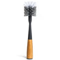 The Replaceable Head Bottle Brush by Grove Co. has a black handle with a wooden grip and dense bristles for cleaning baby bottles and narrow containers. Its sleek design, engraved with Grove, is also ideal for reusable water bottles.