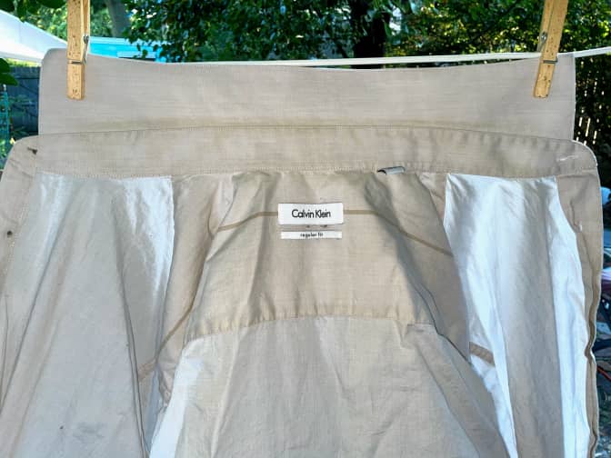 Photo of clean white shirt hanging on clothesline