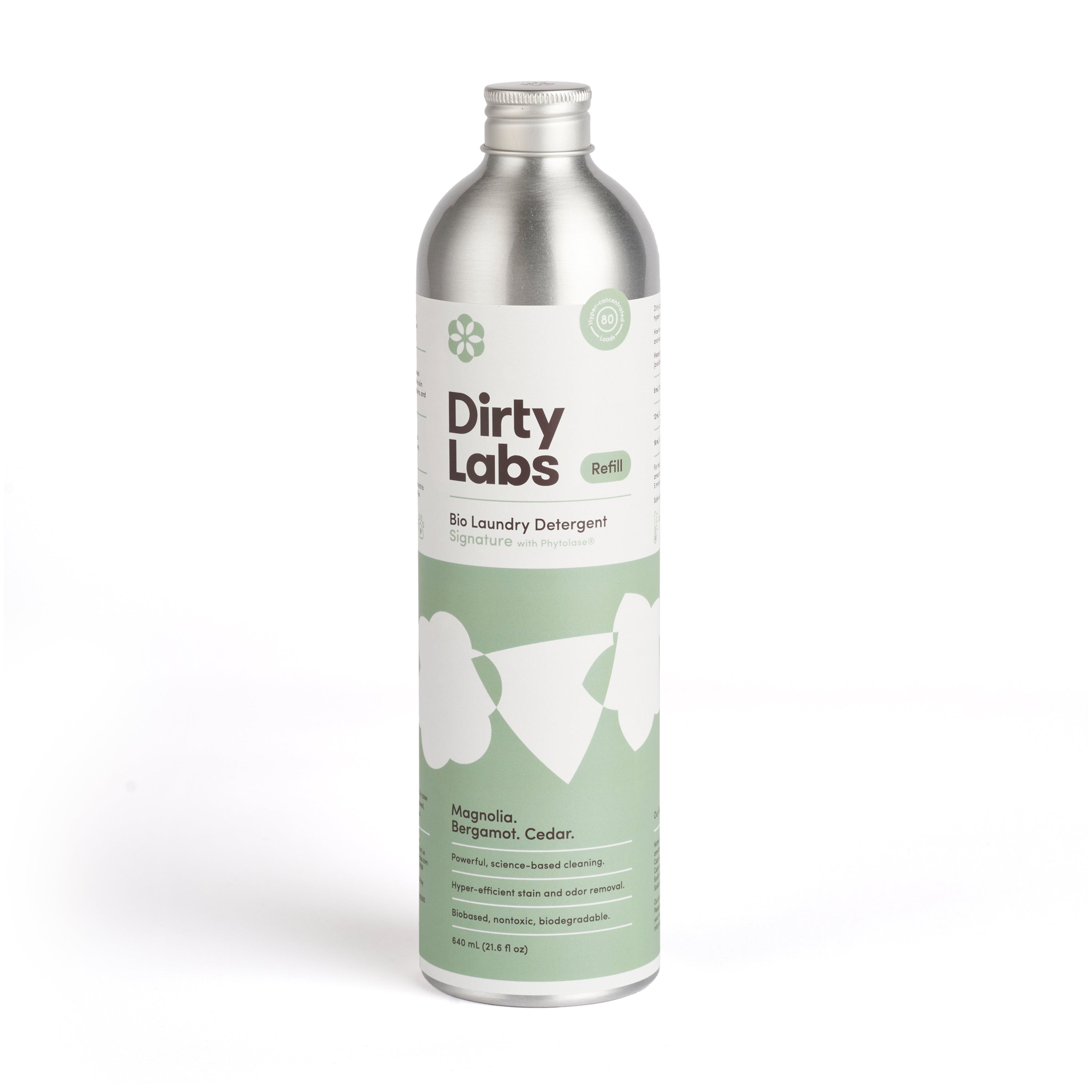 A metallic bottle of Dirty Labs Bio Laundry Detergent with Phytolase®, showcasing green and white labeling, exudes a chic design featuring magnolia, bergamot, and cedar notes. Its eco-friendly, refillable, and part of their natural detergent line.