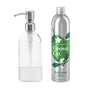 A transparent glass soap dispenser with a metal pump is beside a silver bottle labeled Grove Co. The Dish Soap Starter Set, featuring green leaves and white blossoms, delivers an apple and pear blossom scent. It helps reduce plastic waste, adding an eco-friendly touch to your kitchen.