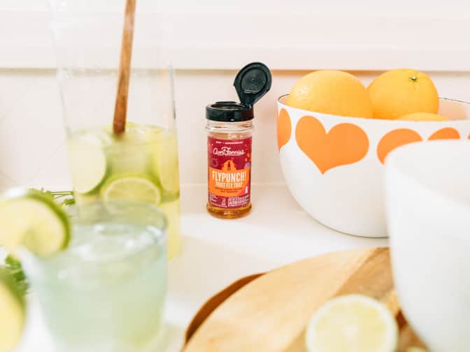 Image of Aunt Fannie's Fly Punch bottle on counter next to produce