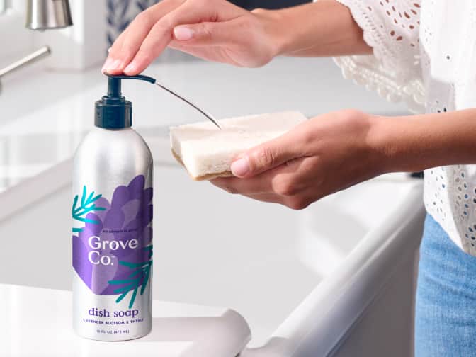 Woman dispensing dish soap from a Grove Co. dish soap bottle.