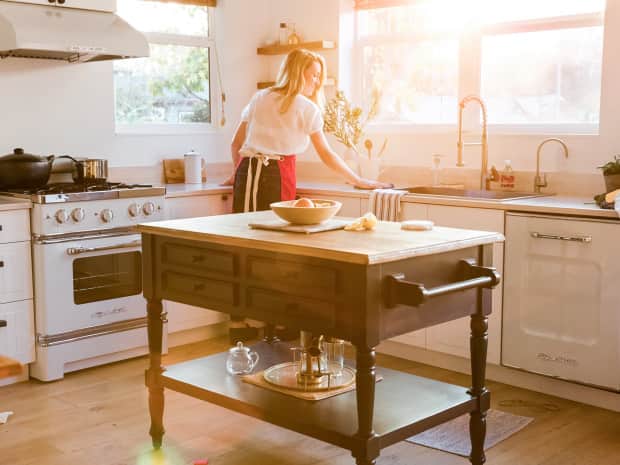woman in the kitchen cleaning counter during sunset