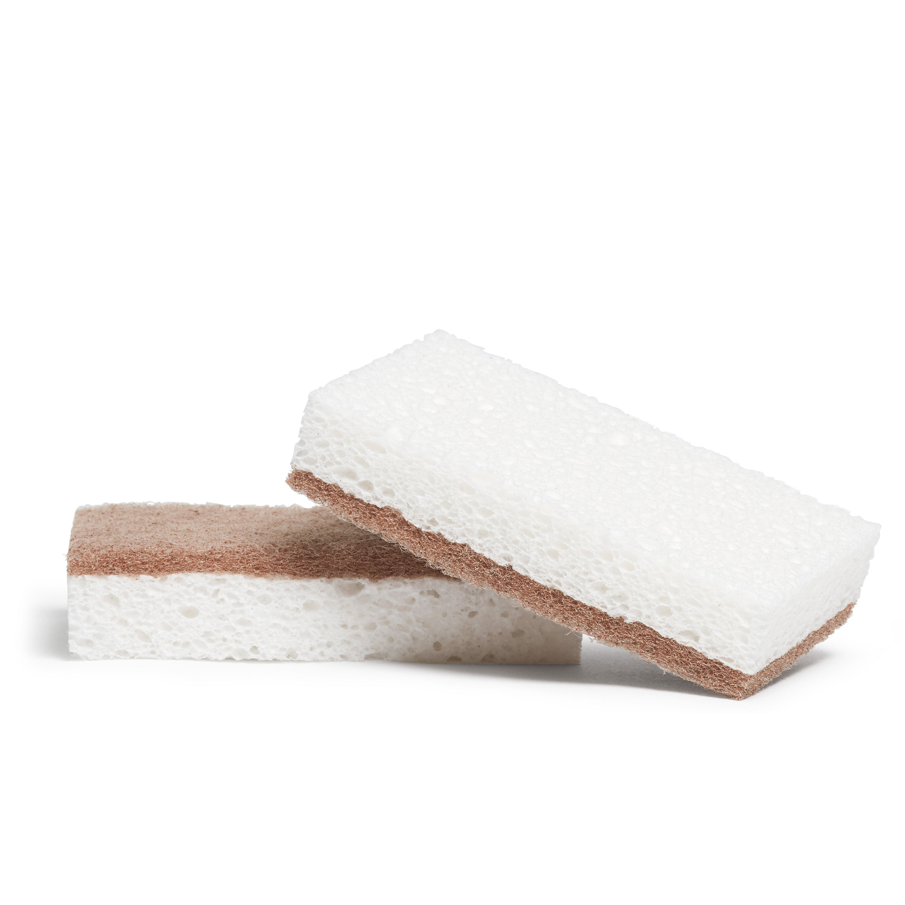 Two Grove Co. walnut scrubber sponges leaning against each other with a white background