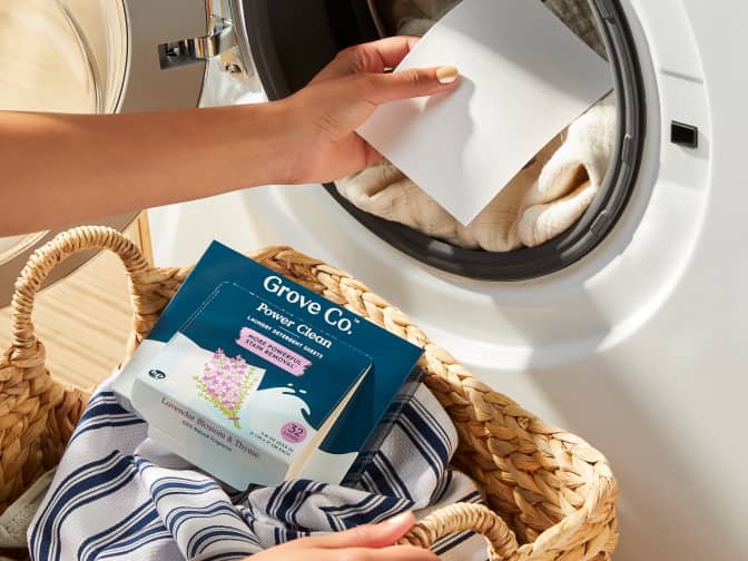 Laundry sheet held above an open dryer 