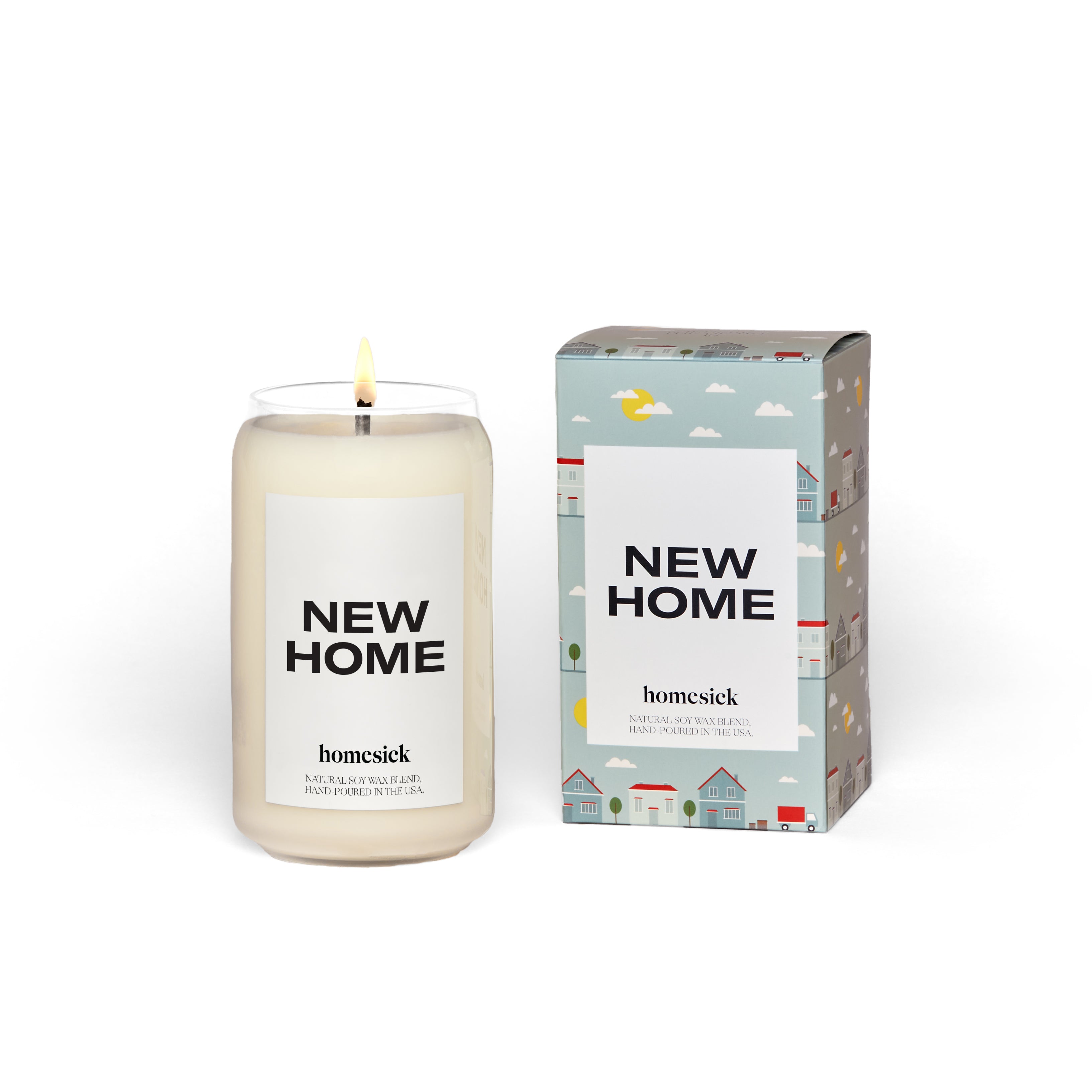 A natural soy wax candle labeled NEW HOME by Homesick rests in a glass jar beside its house-patterned box. Both feature the brands name, and its cruelty-free, making it an ideal gift for any occasion.