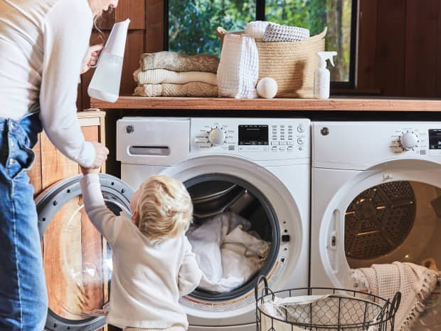 An older adult helping a young child clean their washing machine