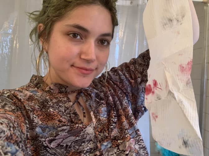 Photo of woman holding towel with makeup on it