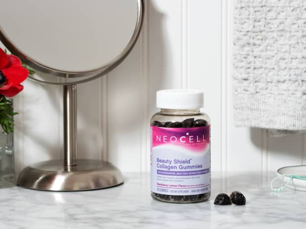 Image of Neocell Collagen Gummies bottle with 2 gummies sitting next to bottle on counter