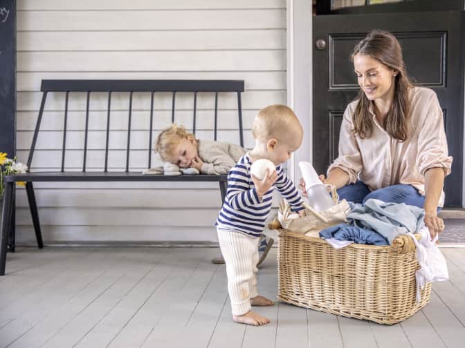 Image of a woman doing laundry with two children