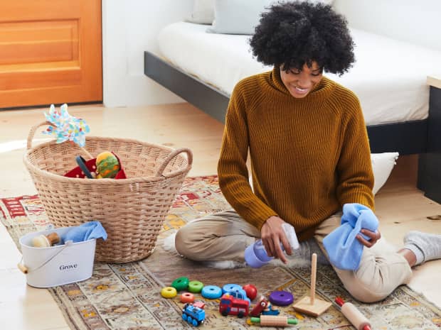 woman cleaning wooden baby toys with cleaning concentrates