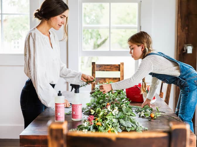 Adult and young child working together at the dinner table removing stains from laundry.
