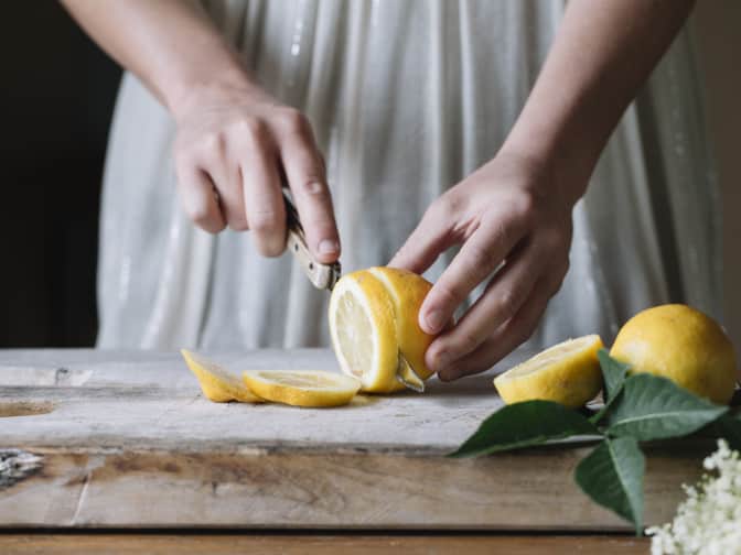 Woman cutting fresh lemons for her natural cleaning products