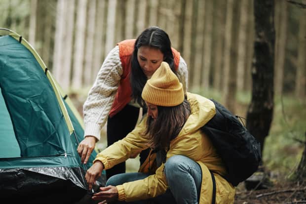 Two women pitching a tent