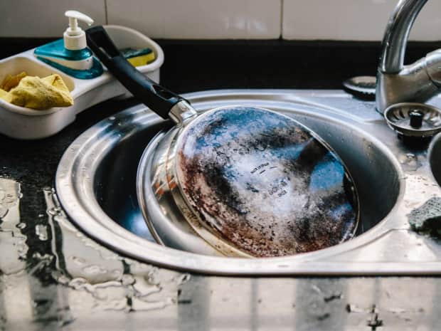 dirty pan pot in a sink kitchen
A cooking pan with a dirty burned bottom lying in the sink