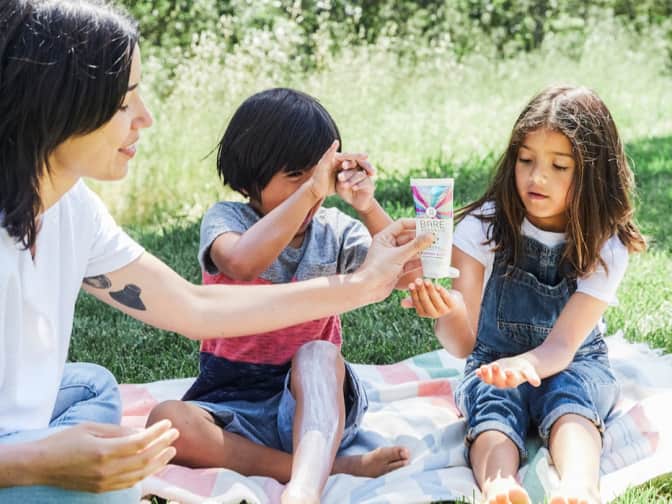 Image of parent putting sunscreen into hand of child 