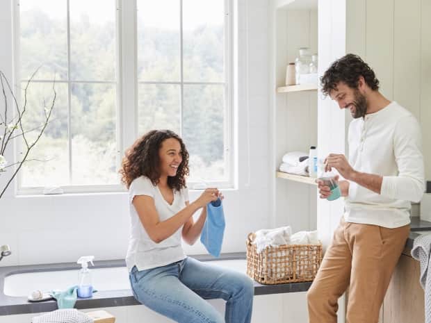 Man and woman smiling in bathroom / laundry room