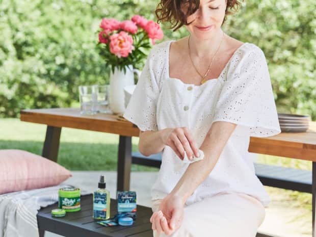 woman in yard with insect repellent products from murphy's naturals and aunt fannie's