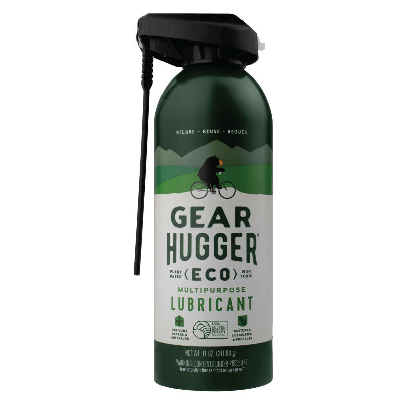 A 10 oz green and white Gear Hugger Multi-Purpose Lubricant can features a spray nozzle, a cyclist on a lush landscape, and the slogan Relube, Reuse, Reduce. This non-toxic lubricant provides rust protection.